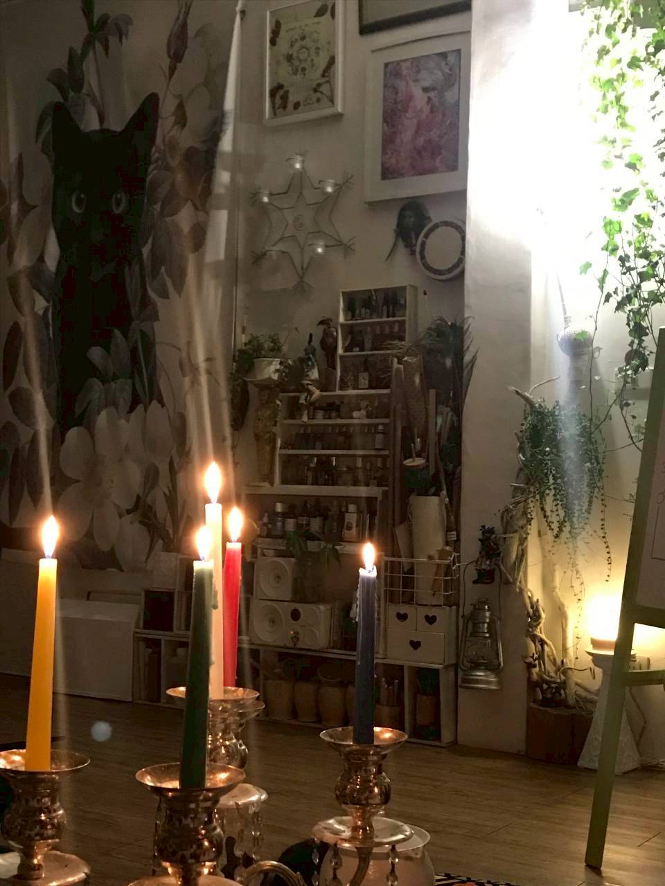 工作室一角點著彩色蠟燭，旁邊擺放植物與五芒星裝飾